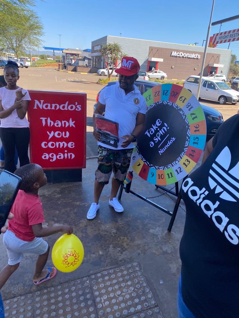 Guests spinning the prize wheel at a Nando's activation