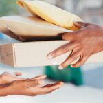 close-up-image-of-hands-exchanging-packages-outdoors.-represents-delivery-and-shipping-services.-6868618-scaled